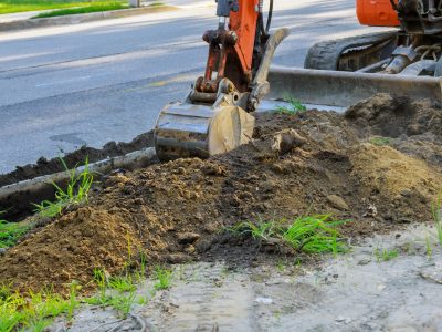 Digger working at construction in excavation pit
